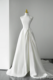 White wedding dress on a mannequin against a gray background
