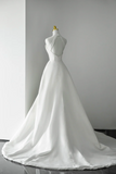 White wedding dress on a mannequin against a gray background