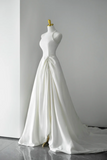 White wedding dress on a mannequin against a plain background
