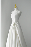 White wedding dress on a mannequin against a gray background