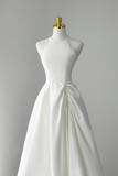 White wedding dress on a mannequin against a gray background