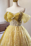 Yellow evening gown with floral details on a mannequin against a neutral background