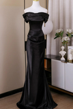 Black evening gown on a mannequin against a neutral background