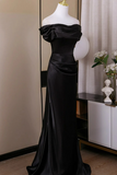 Black evening gown on a mannequin against a neutral background