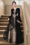 Woman in a black and silver evening gown standing on a staircase.