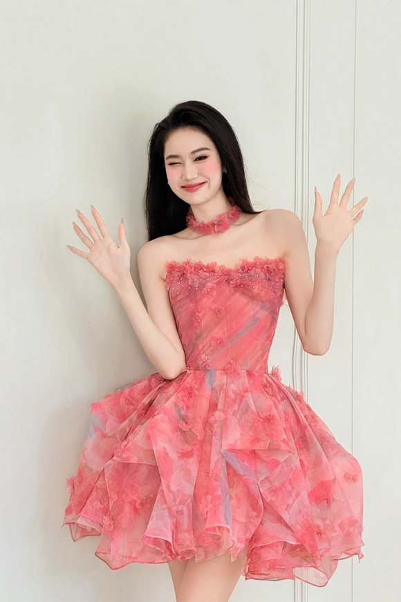 Woman wearing a pink dress against a white wall