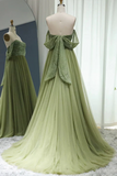 Green evening gown on a mannequin with a white curtain background