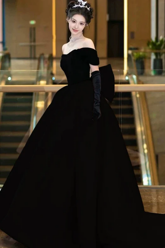 Woman in a black evening gown with gloves in an indoor setting