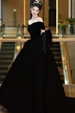Woman in a black evening gown with gloves in an indoor setting