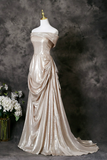 Elegant silver evening gown on a mannequin against a dark background
