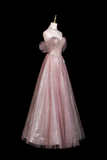 Pink evening gown on a mannequin against a black background