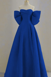 Blue evening gown with large bow details on a mannequin against a plain background