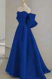 Blue evening gown on a mannequin against a plain background