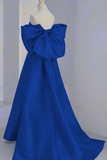 Blue evening gown with a large bow on a mannequin against a plain background