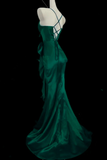 Green evening gown on a mannequin against a black background