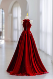 Red evening gown on a mannequin against a white background