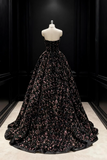 Black floral gown on a mannequin against a dark background