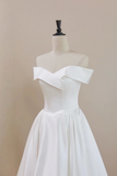 White off-shoulder dress on a mannequin against a beige background
