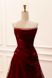 Red strapless gown on a mannequin against a white background