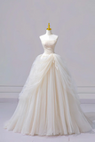 White wedding dress on a mannequin against a plain background