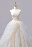 White wedding dress on a mannequin against a plain background