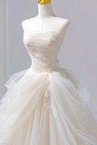 White wedding dress on a mannequin against a plain background