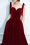 Burgundy evening gown with bow straps on a plain background