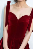 Red velvet dress with bow straps on a plain background