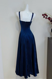 Navy blue dress on a mannequin against a white background
