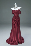 Burgundy evening gown on a mannequin against a gray background