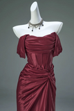 Maroon evening gown on a mannequin with a gray background