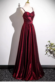 Red evening gown on a mannequin against a white wall.