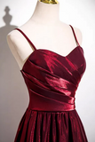 Red evening gown on a mannequin against a plain background