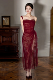 Woman wearing a burgundy lace dress in an elegant indoor setting