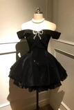 Black dress with bow detail on a mannequin against a neutral background