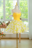 Yellow dress with floral pattern on a mannequin in front of a window with greenery.
