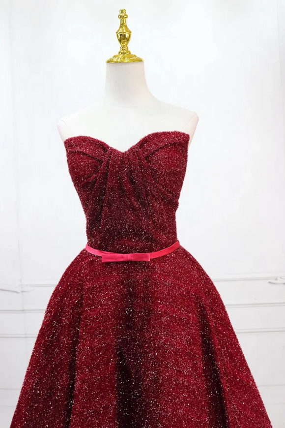 Red strapless dress on a mannequin against a white background
