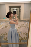 Woman taking a mirror selfie in a formal dress in an elegant interior setting.