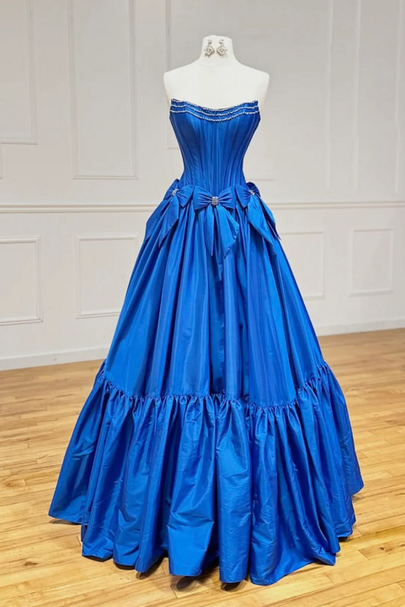 Blue ball gown on a mannequin against a white wall.