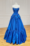 Blue ball gown on a mannequin against a white wall.