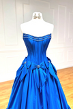 Blue evening gown with a bow detail on a mannequin against a white background