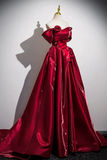 Red evening gown on a mannequin against a plain background