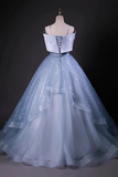 Light blue evening gown on a mannequin against a dark background