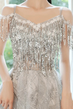 Silver beaded dress with fringe details on a blurred background