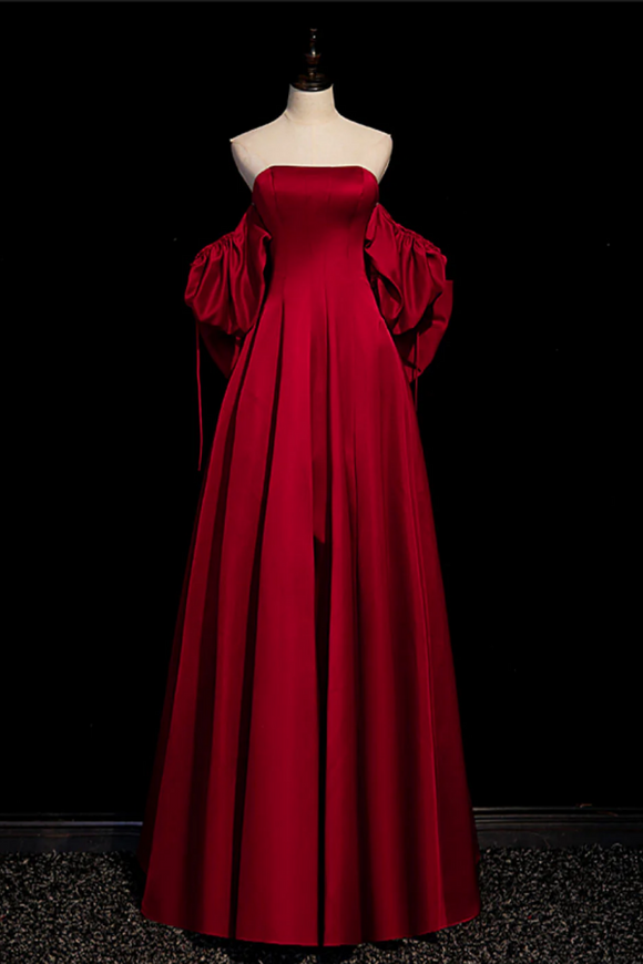 Red evening gown on a mannequin against a black background