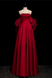 Red evening gown on a mannequin against a black background