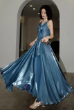 Woman wearing a blue evening gown standing in an archway.