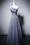 Gray strapless evening gown on a mannequin against a gray background