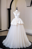 White wedding dress on a mannequin against a neutral background