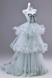 Light blue evening gown with floral embellishments on a mannequin against a gray background